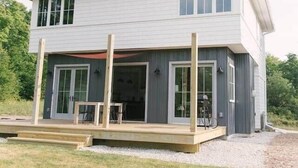 A modern two-story house with a covered porch and large windows. - Sister Bay Eclectic Cottage (Sister Bay)