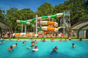 Una piscina con toboganes y una torre de socorristas.