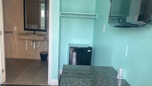 Uma cozinha compacta com bancada, pia e geladeira.