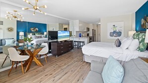Eine moderne Wohnung mit Essbereich, Küche und einem großen Bett.