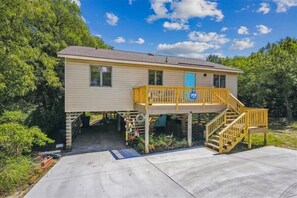 A single-story house with a front porch and a small deck. - Adorable 4 BR, short walk to the beach in Southern Shores! (Southern Shores)
