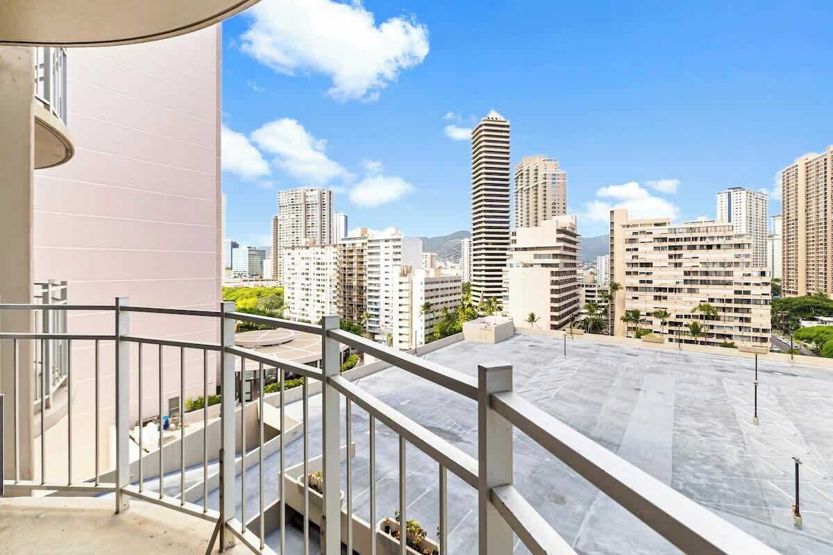 A high-rise building with a modern design, featuring multiple balconies and a clear view of the surrounding urban landscape.