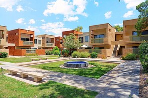 A courtyard with a central fountain, surrounded by multi-story buildings with balconies and a small tree. - Dog Friendly - 2 Patios Heated Pool, Spa & Fitness (Scottsdale)
