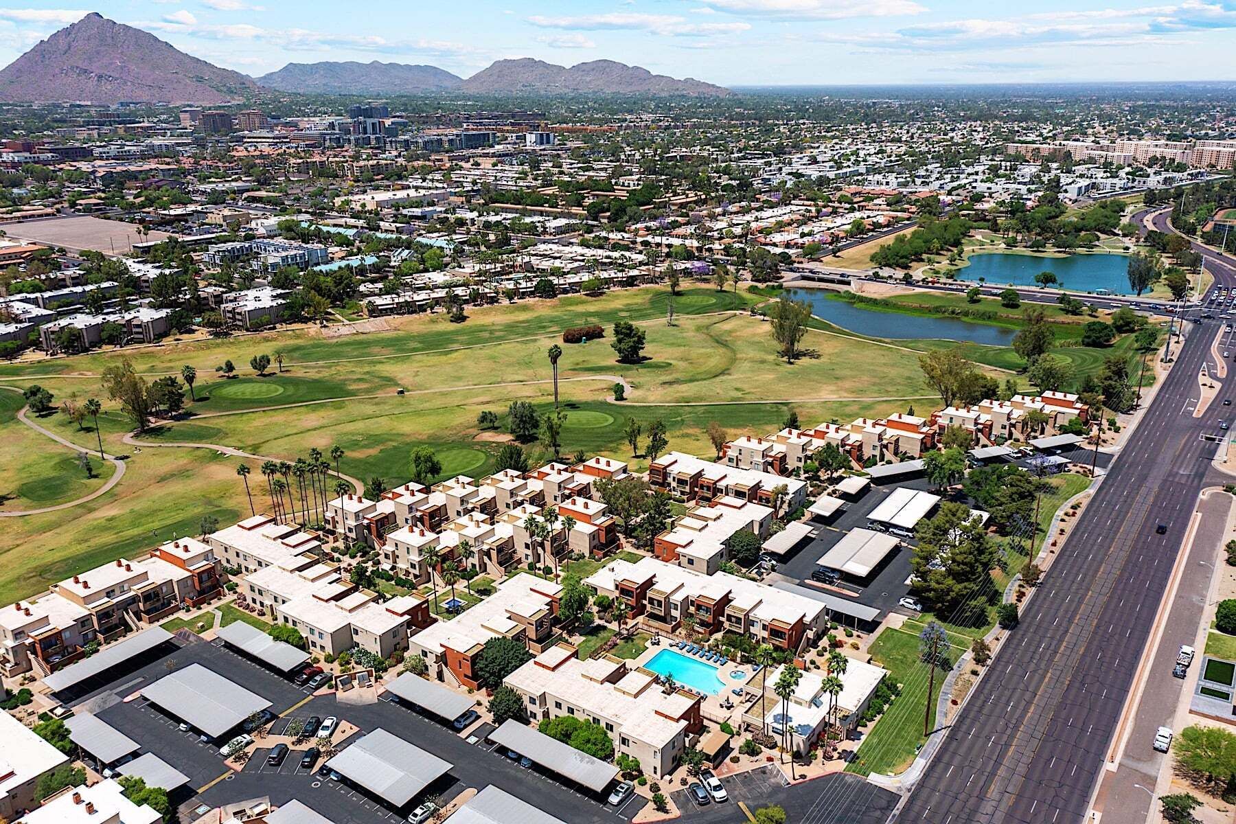 Vista aérea de una zona residencial con edificios de apartamentos, un campo de golf y un lago.