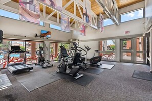 A gym with treadmills, stationary bikes, and elliptical machines, large windows, and an exit sign. - Dog Friendly - 2 Patios Heated Pool, Spa & Fitness (Scottsdale)