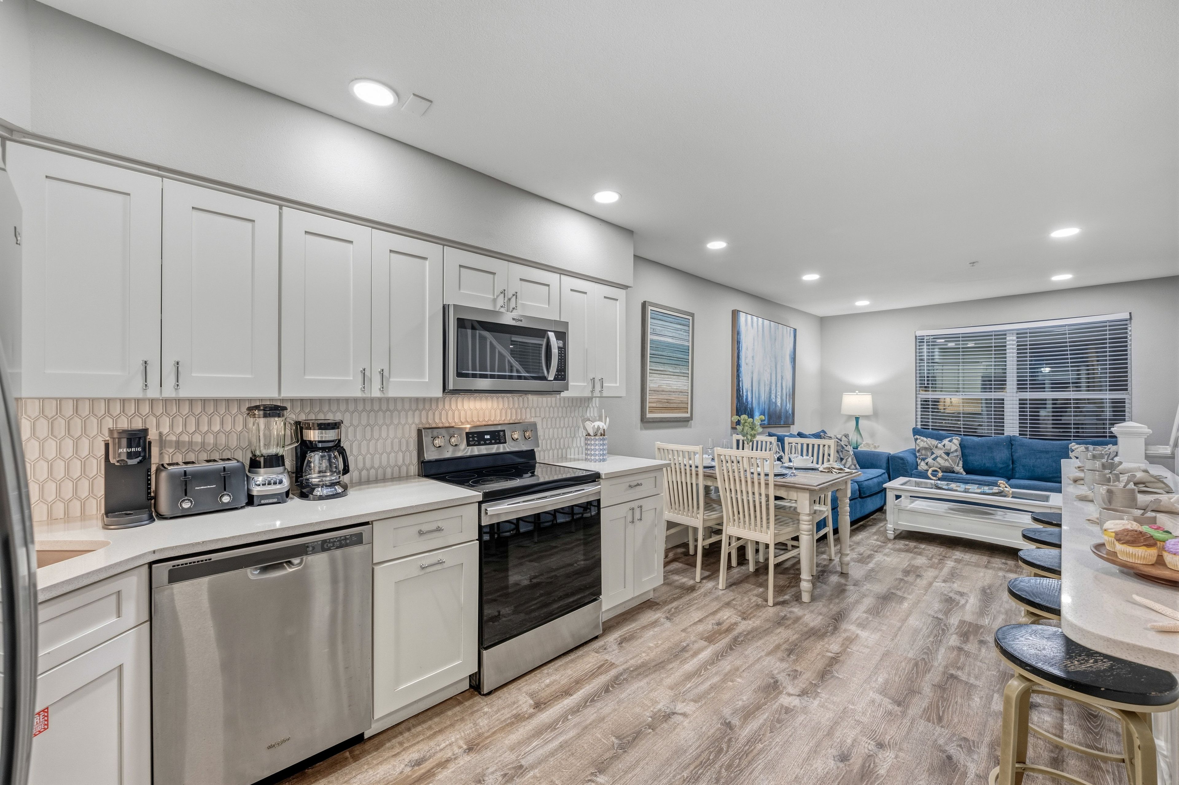 A modern kitchen with white cabinetry, a built-in microwave, and a dishwasher.