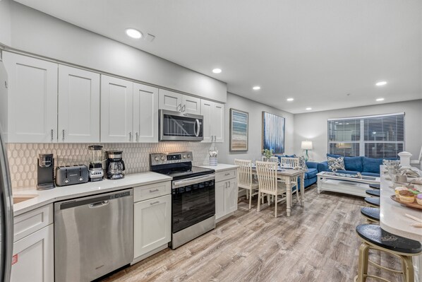 A modern kitchen with white cabinetry, a built-in microwave, and a dishwasher.