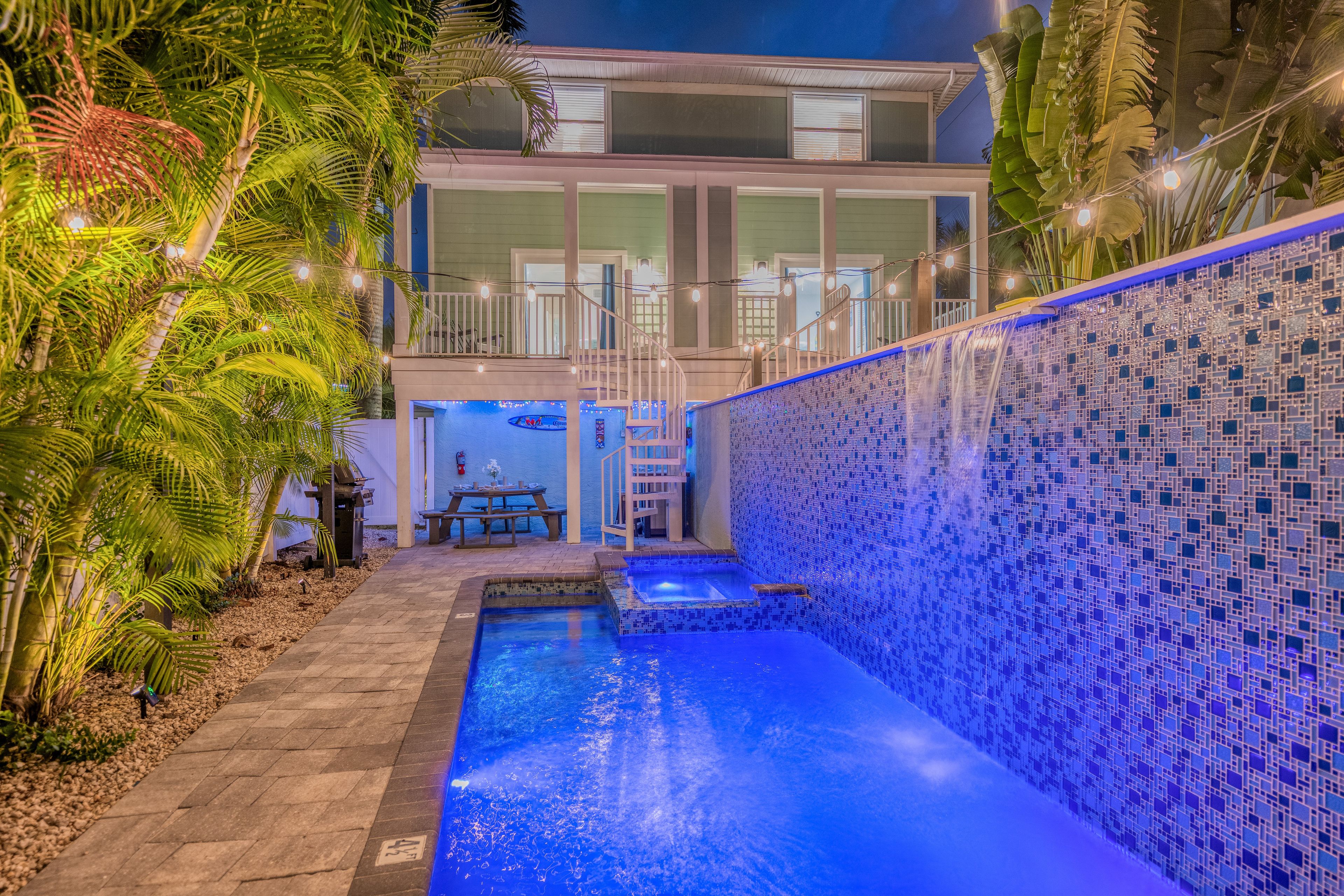 Ein zweistöckiges Gebäude mit Swimmingpool und Balkon.