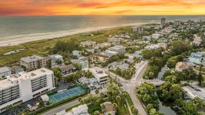 An aerial view of a coastal residential area with buildings, roads, and a beach.
