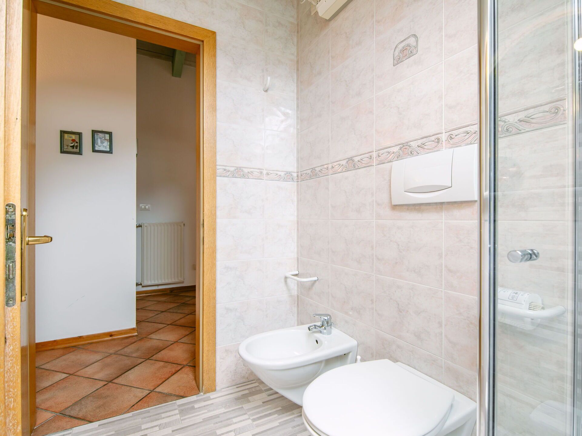Une salle de bain comprenant des toilettes, un bidet et un espace douche.