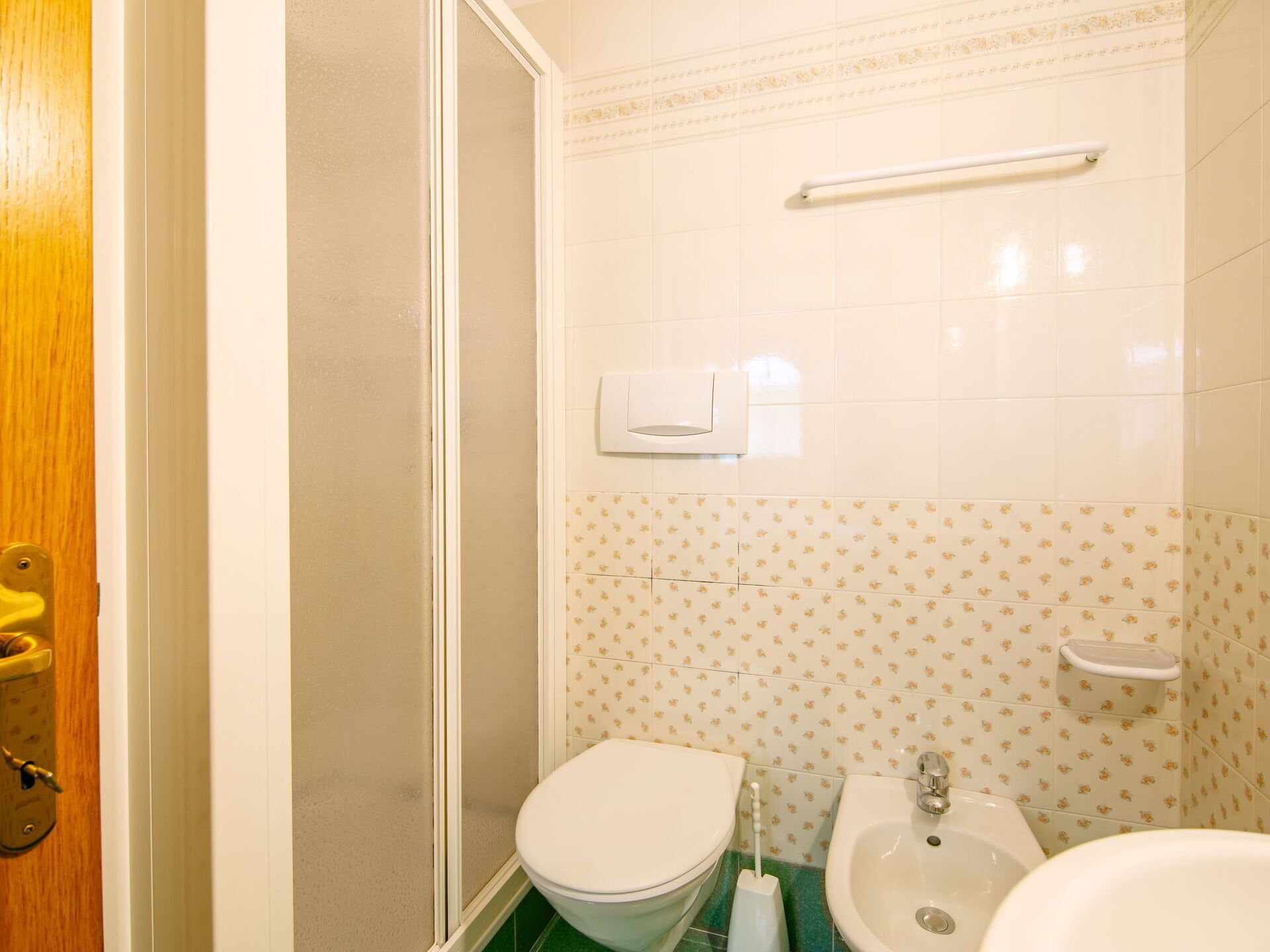 A bathroom with a toilet, bidet, and sink.
