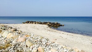 A beach with a rocky shoreline and calm sea. - Welcoming holiday home right down to the water (Rørvig)