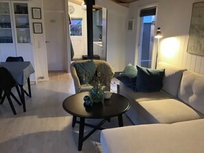 A living room with a sofa, armchair, coffee table, and a lamp.