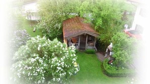 Une petite construction rustique en bois, dotée d’un toit en pente, entourée d’une végétation luxuriante et d’une pelouse bien entretenue.
