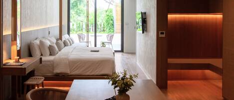 Quarto de hotel moderno com cama, escrivaninha, cadeira e vista para o exterior.