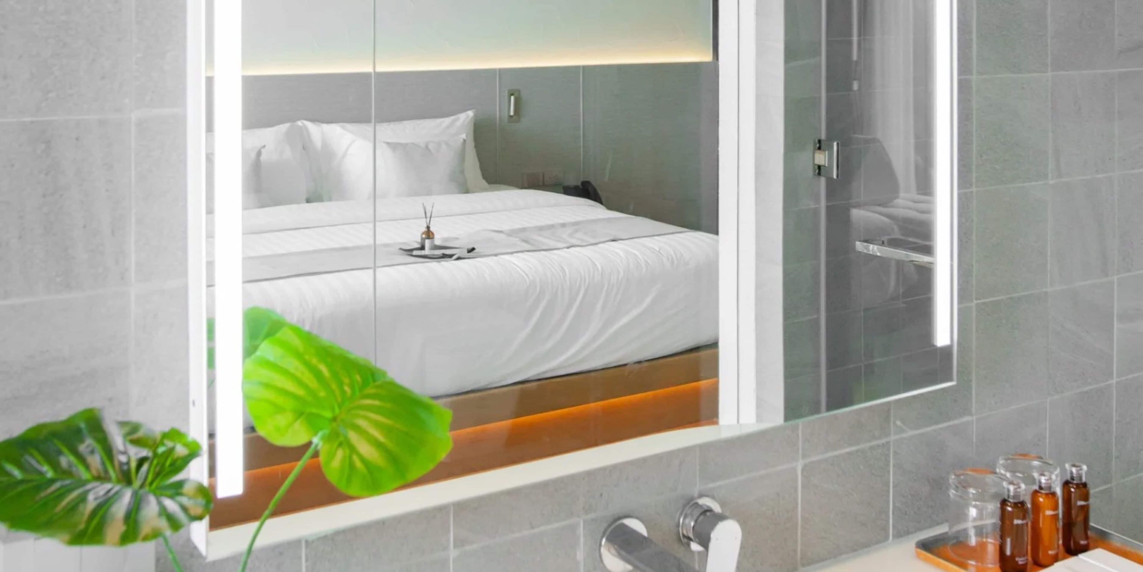 A modern bathroom with a large mirror, a sink, and toiletries.