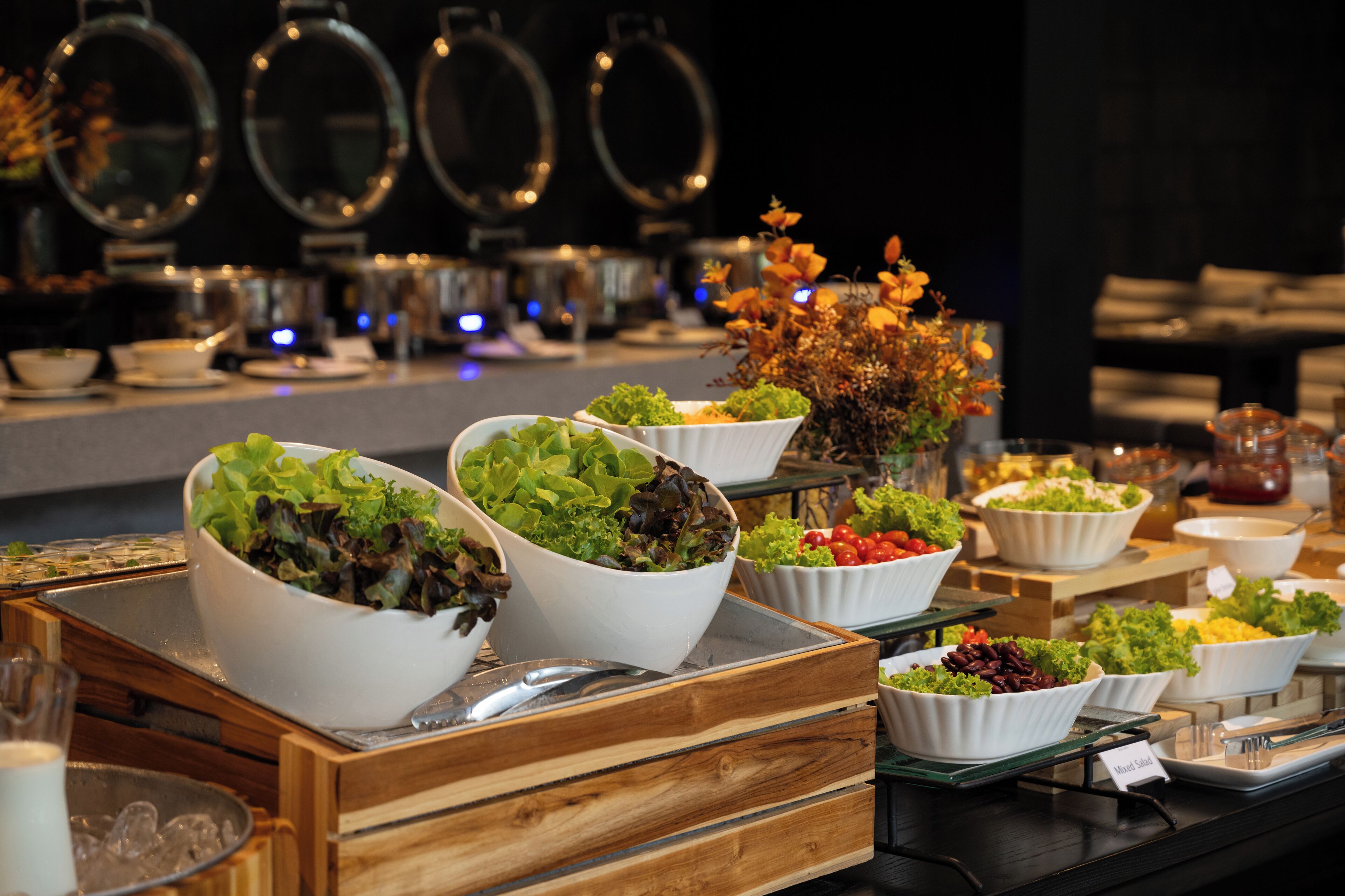En buffet med forskellige skåle med salat og andet mad.