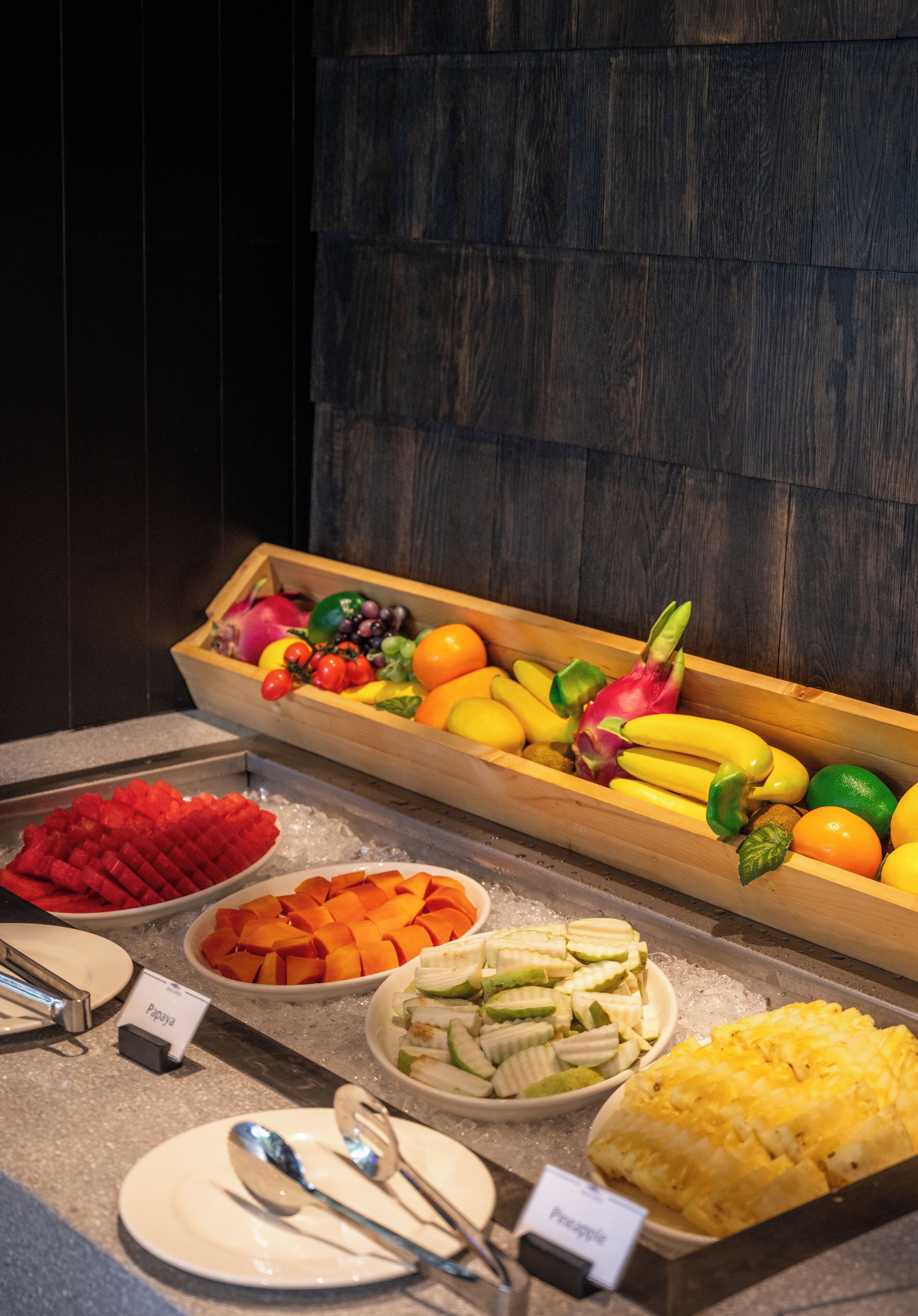 Un bufé con diversas frutas, verduras y un plato de piña.
