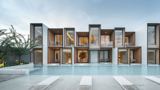 A modern hotel with multiple balconies, a swimming pool, and a landscaped garden area. - Riva Vista Riverfront Resort Chiangrai (Chiang Rai)