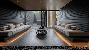 A modern interior with a central coffee table, two sofas, and a view through a glass door. - Riva Vista Riverfront Resort Chiangrai (Chiang Rai)
