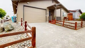 Un bâtiment d’un seul étage, doté d’un garage, d’un porche couvert et d’une allée gravillonnée.