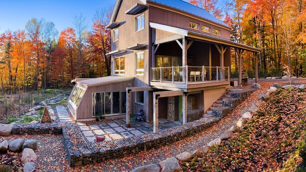A modern two-story house with a large deck and a covered outdoor seating area. - Le Camp Caché Shefford (Shefford)