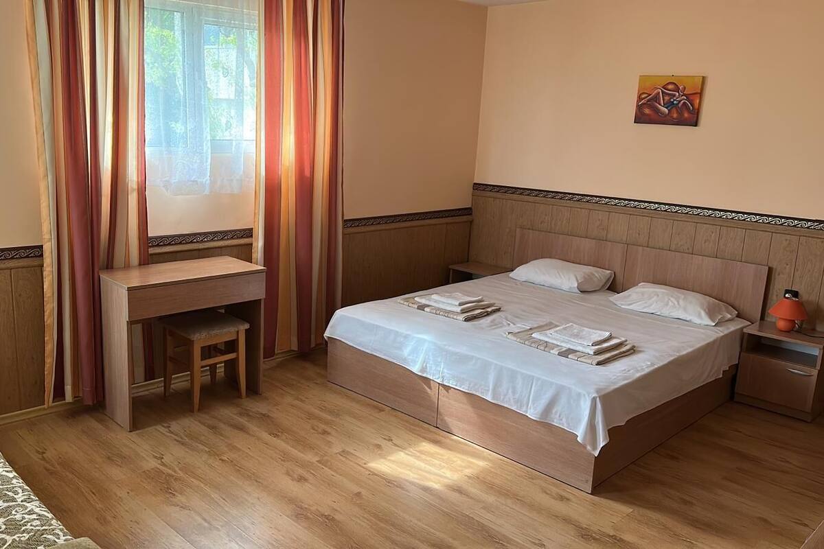 A hotel room with a wooden bed, a desk, and a chair.
