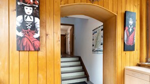 A wooden interior with a staircase, a black mat at the bottom, and two paintings on the walls. - Apartment "Völker" with Shared Garden & Wi-Fi (Haslach im Kinzigtal)
