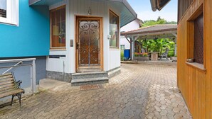 A corner building with a wooden door, a bench, and a paved walkway. - Apartment "Völker" with Shared Garden & Wi-Fi (Haslach im Kinzigtal)