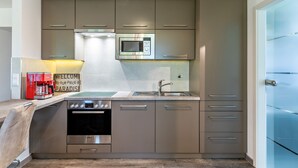 Een moderne keuken met een inbouwoven, magnetron en roestvrijstalen apparatuur.