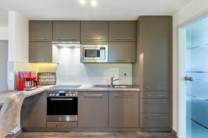 Una cucina moderna con forno integrato, microonde ed elettrodomestici in acciaio inossidabile.