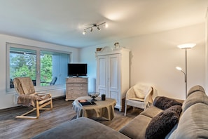 A living room with a sofa, armchair, table, TV, and wardrobe. - Apartment 'Eulennest' with Terrace and Wi-Fi (Schramberg)