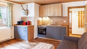 Una cocina compacta con armarios de madera, un horno empotrado y una zona de comedor con mesa.