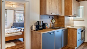 A compact kitchen with wooden cabinets, a sink, and a stove. - Renovared Apartment "Lengdobler - Leni" with Mountain View, Balcony & Wi-Fi (Bad Kohlgrub)