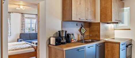 A compact kitchen with wooden cabinets, a sink, and a stove.