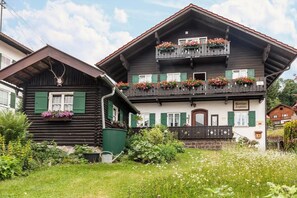 A traditional chalet with a balcony, a log cabin, and a garden. - Renovared Apartment "Lengdobler - Leni" with Mountain View, Balcony & Wi-Fi (Bad Kohlgrub)