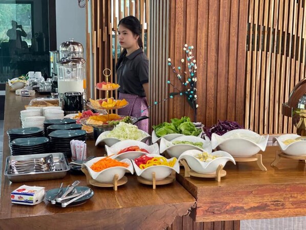 Un buffet proposant une variété de plats et d'ustensiles.