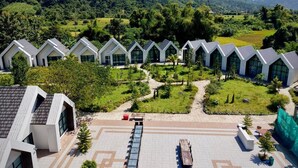 A modern hotel with a series of white buildings with sloped roofs, arranged in a row. - Xaymone Riverside Resort and Restaurant (Vang Vieng)
