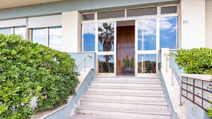 A building entrance with a staircase, a large window, and a potted plant. - Annamaria's House Beachfront in Viareggio, Viareggio, Italy (Viareggio)