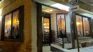 A building with a neon sign reading "panuchais" and a sign indicating "TSUNAMI RUA DE DESALOGIO" with an arrow pointing left. - House near the beach 4B/2Bath (San Juan)
