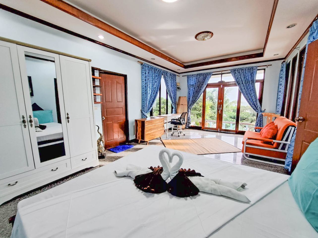 Habitación de hotel con cama, armario, escritorio y vistas al exterior.