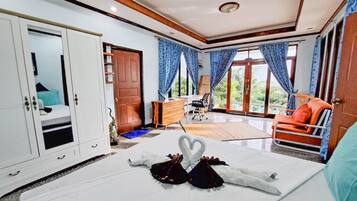 Habitación de hotel con cama, armario, escritorio y vistas al exterior.