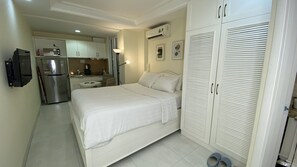 Une chambre d’hôtel comprenant un lit, une armoire, un coin cuisine et une salle de bain.