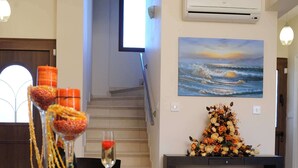 Un comedor con una mesa larga, centros de mesa decorativos y un cuadro en la pared.