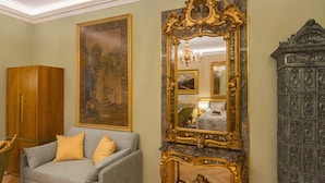 A room with a large ornate mirror, a grey sofa with yellow cushions, and a wooden cabinet. - Superb Arena View (Pula)