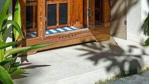 A wooden door with a built-in bench and a small step leading up to it. - Villa Kalimaya (Seminyak)