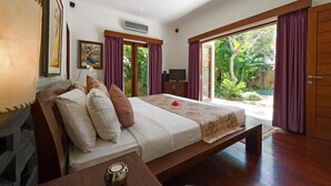 A bedroom with a bed, a TV, and a view of the outdoors. - Villa Kalimaya (Seminyak)
