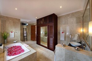 A modern bathroom with a large bathtub, a separate shower area, and a vanity with a sink.