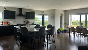 Eine moderne Küche mit dunklen Schränken, einer Mittelinsel und Barhocker.