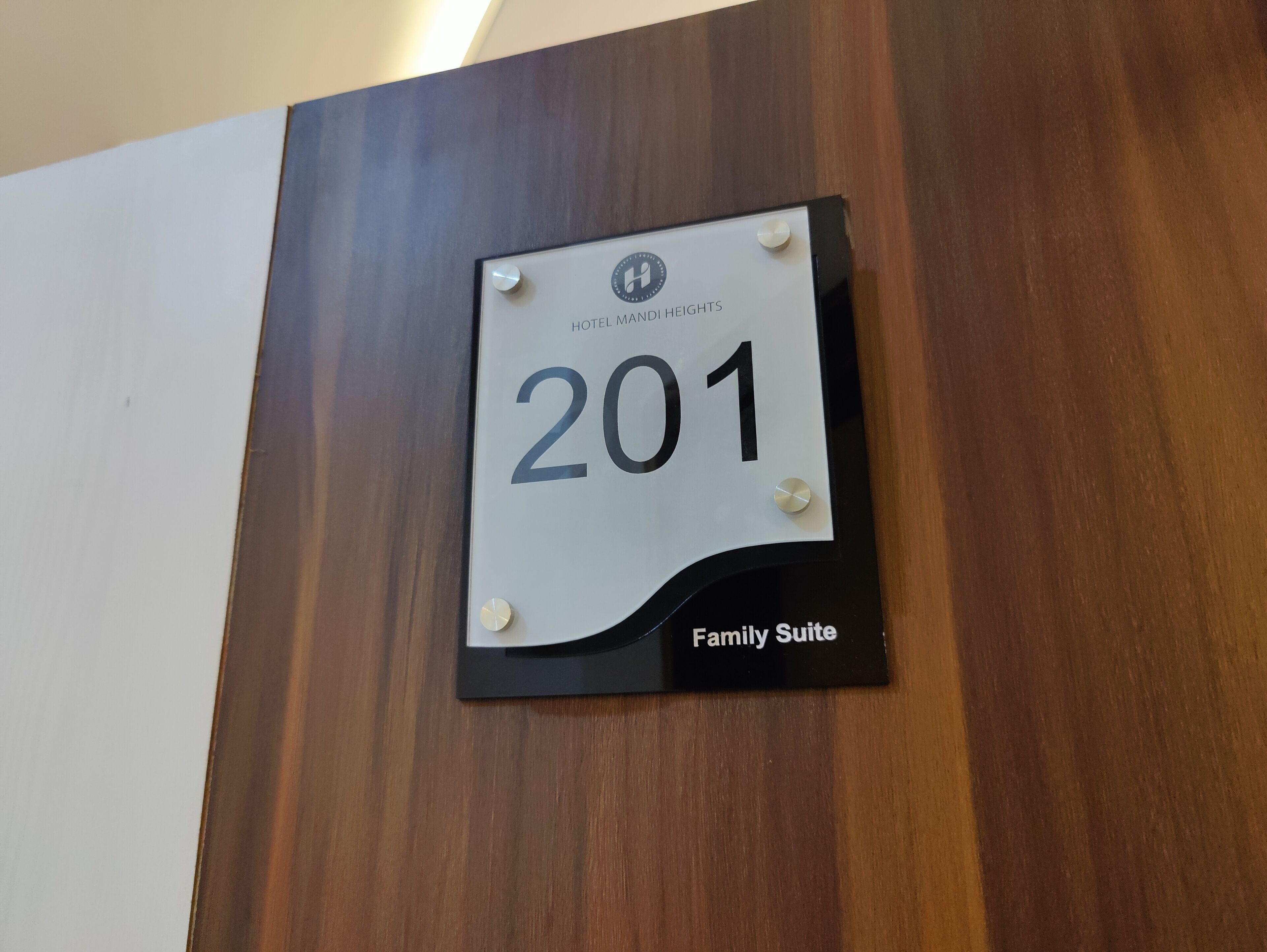 A hotel room sign with the number 201 and the label "Family Suite".